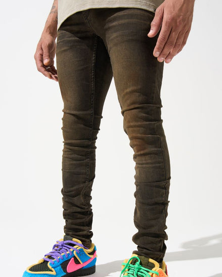 Person wearing dark jeans and colorful sneakers on a white background
