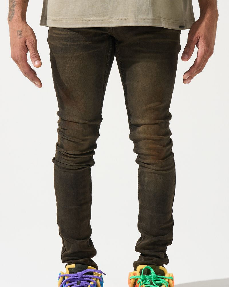 Person wearing dark jeans and colorful sneakers on a white background