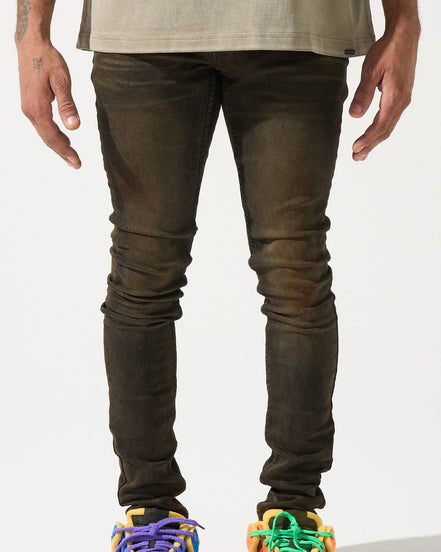 Person wearing dark jeans and colorful sneakers on a white background