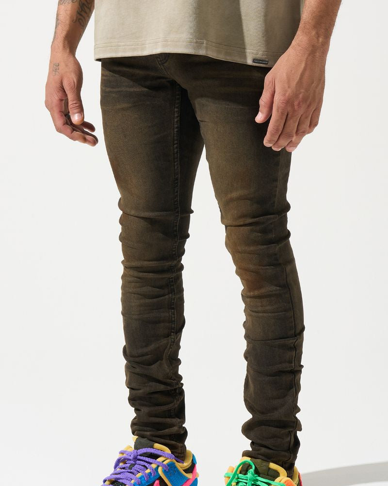 Person wearing dark jeans and colorful sneakers on a white background