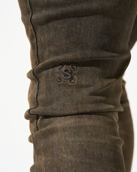 Close-up of brown pants with a logo on a white background
