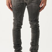 Person wearing black distressed jeans and black sneakers on a white background