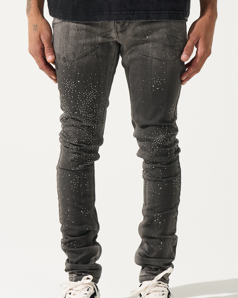 Person wearing black distressed jeans and black sneakers on a white background