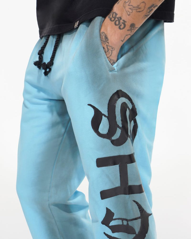 Light blue jogger pants with black text design on a white background