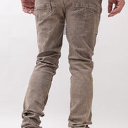 Person wearing brown jeans and white sneakers on a white background