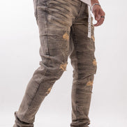 Person wearing distressed gray jeans and white sneakers on a white background