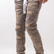 Person wearing distressed gray jeans with a white background