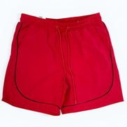 Red shorts with black piping on a white background