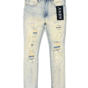 Light wash distressed skinny jeans with ripped details on the thighs and knees, featuring a black ANOM brand tag on the pocket.