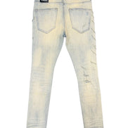 Back view of light-wash distressed jeans with faded yellowing and scuff marks, featuring a black brand patch on the left back pocket.