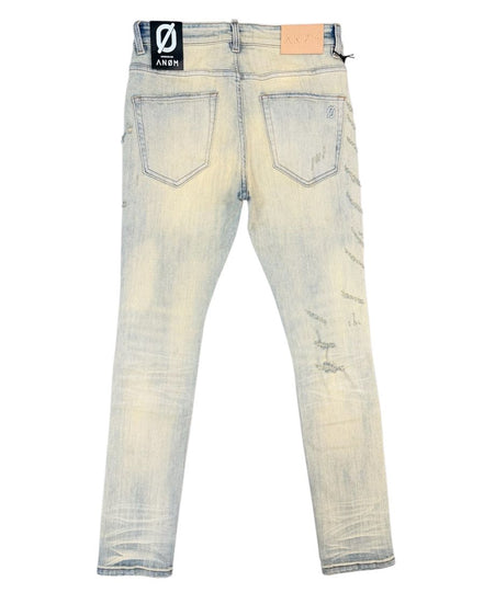 Back view of light-wash distressed jeans with faded yellowing and scuff marks, featuring a black brand patch on the left back pocket.