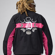 A man viewed from behind wearing a black windbreaker jacket with bright pink side panels and a large white graphic logo on the back, paired with black pants against a light gray studio background.