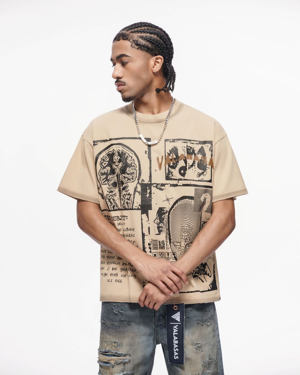 Man wearing a beige t-shirt with graphic design on a white background