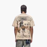 Person wearing a beige t-shirt with graphic design on the back, standing against a white background