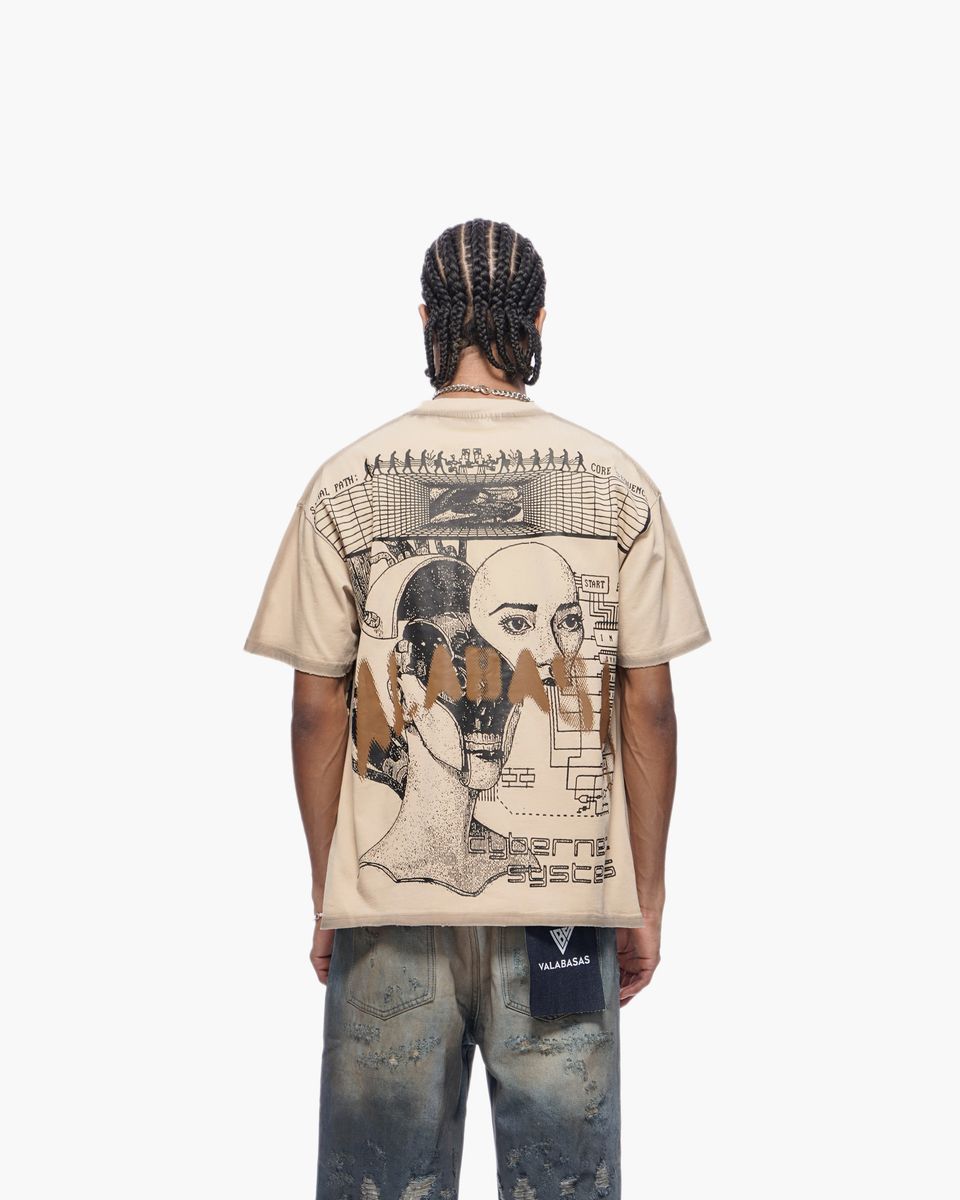 Person wearing a beige t-shirt with graphic design on the back, standing against a white background