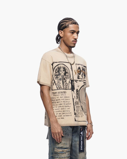 Man wearing a beige t-shirt with graphic design and text, standing against a white background