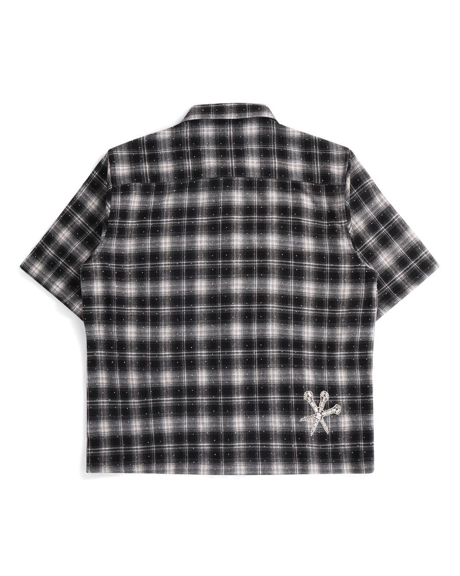 Black and white plaid shirt with a logo on the back on a white background