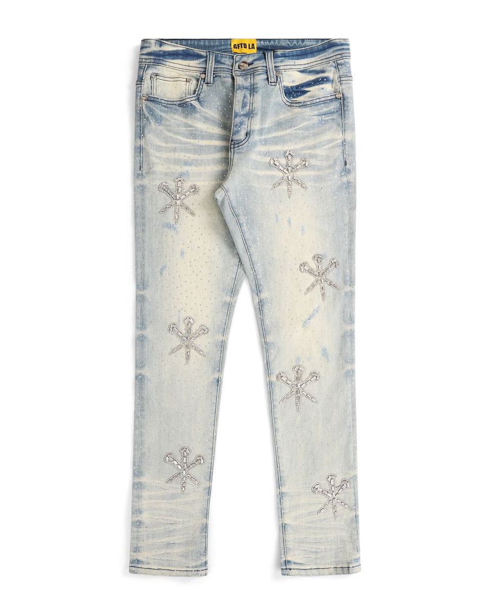 Light blue distressed jeans with decorative snowflake patterns on a white background