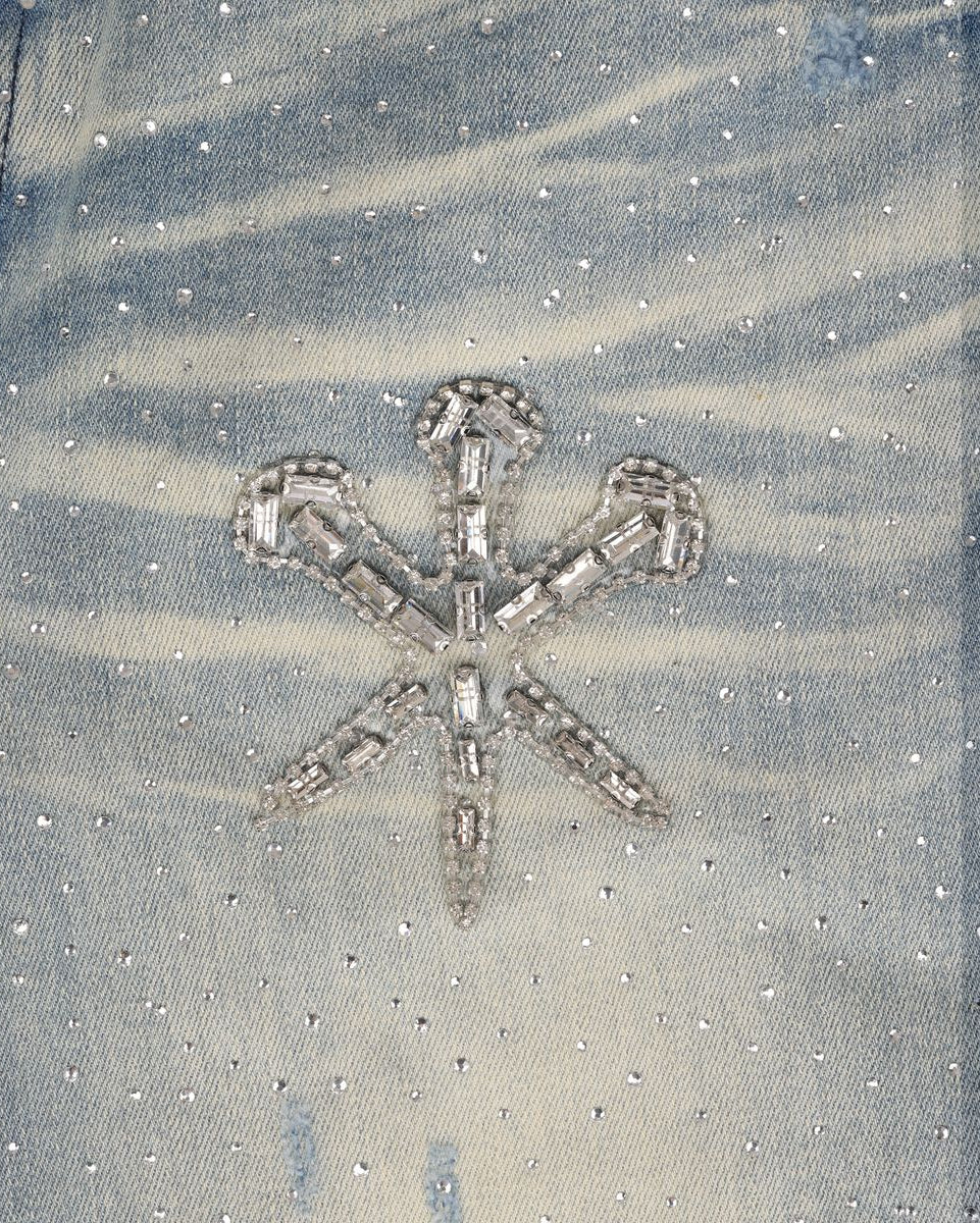 Decorative stones and beads on a textured jean fabric background