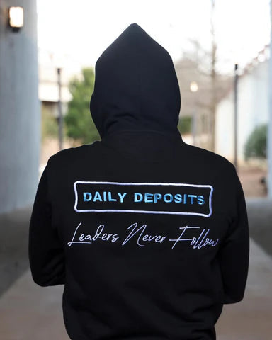 Person wearing a black hoodie with text on the back walking through a tunnel.