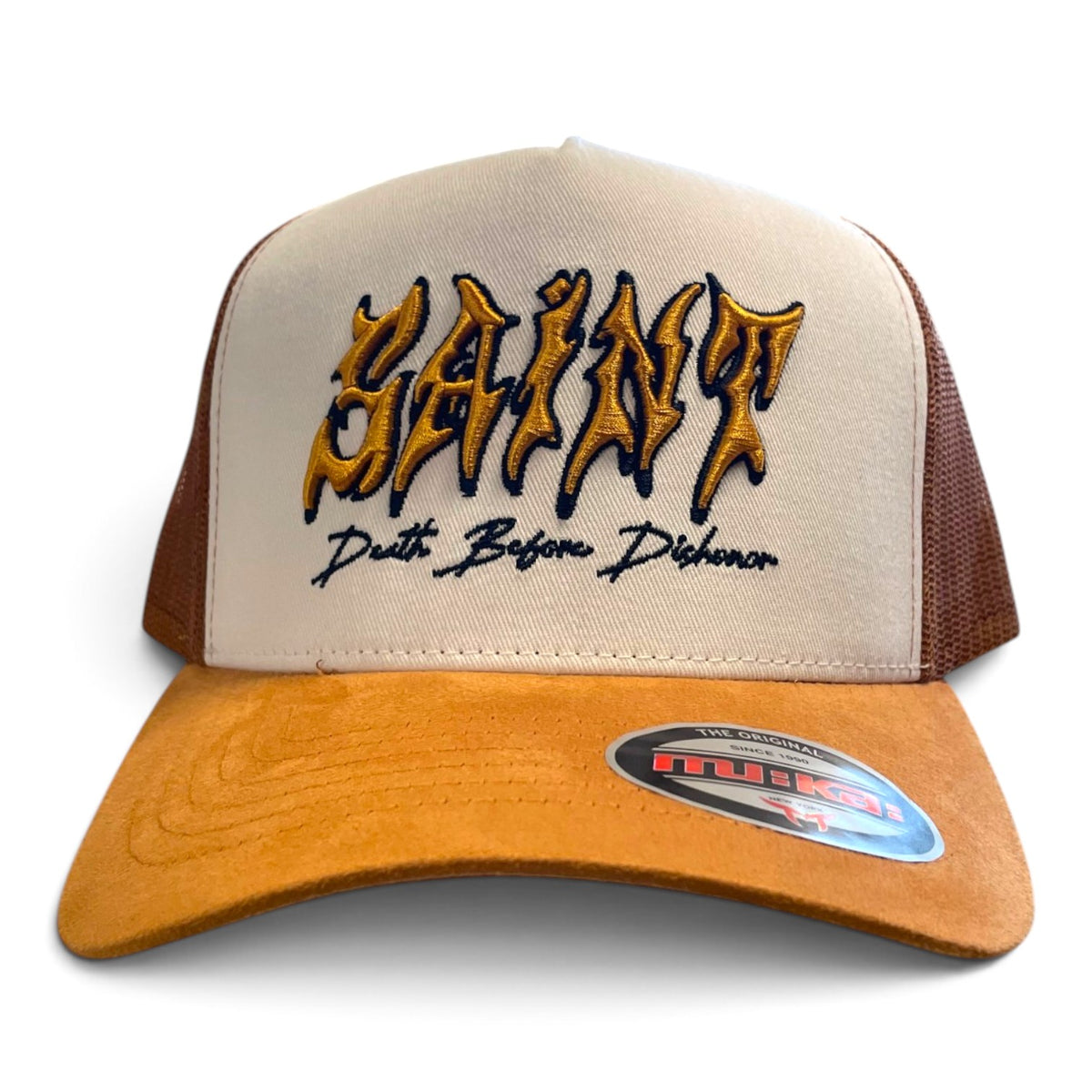 A beige and brown trucker hat with 'SAINT' embroidered in a gold and black gothic font on the front, with 'Death Before Dishonor' stitched below. The brim is a warm tan suede, and the back panels are beige mesh with brown side panels.
