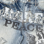 Close-up of blue jeans with embellishments and text