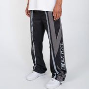 Person wearing black and gray pants with a logo on a white background