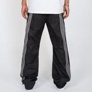 Black pants with gray stripes worn by a person on a white background