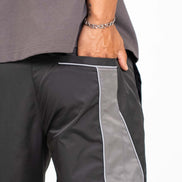 Gray pants with white trim worn by a person on a white background