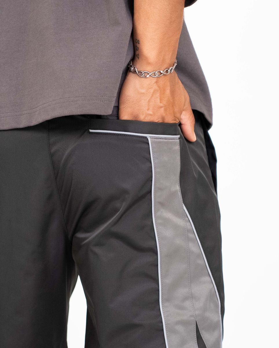 Gray pants with white trim worn by a person on a white background