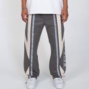 Person wearing gray pants with white and IRRIDESCENT stripes on a white background