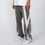Person wearing gray pants with a geometric pattern and white sneakers on a white background