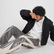 Person wearing a black jacket and gray pants with 'EPTM' branding on a white background