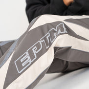 Close-up of a gray and white jacket with 'EPTM' branding.