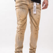Beige distressed jeans worn by a person on a white background