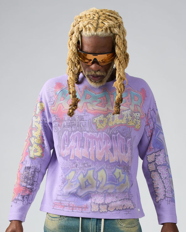 Person wearing a purple graphic sweatshirt with colorful text and designs on a gray background