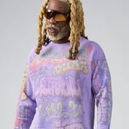 Person wearing a purple graphic sweatshirt with colorful text and designs on a plain background