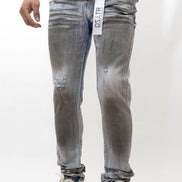 Person wearing gray distressed jeans with a white background