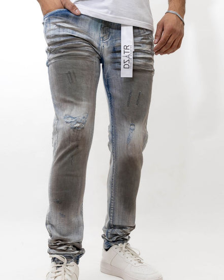 Person wearing distressed gray jeans with a visible brand label on a white background