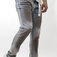 Person wearing distressed gray jeans with a white background