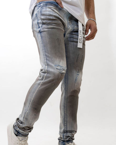 Person wearing distressed gray jeans with a white background
