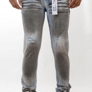 Person wearing gray distressed jeans with a visible brand label on a white background