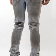 Person wearing light gray distressed jeans and white sneakers on a white background