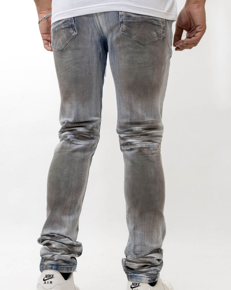 Person wearing light gray distressed jeans and white sneakers on a white background