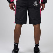 Black athletic shorts with pink side panels and a white graphic logo on the left hip, shown on a model from the back against a light gray studio background.