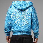 Blue camouflage hoodie with a brand logo on the back, worn by a person against a gray background.