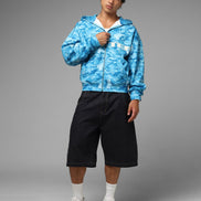 Person wearing a blue camouflage hoodie and black shorts on a gray background