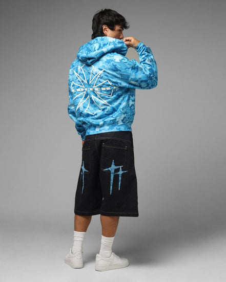 Person wearing a blue tie-dye hoodie and black shorts with blue designs on a gray background