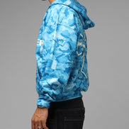 Person wearing a blue camouflage jacket on a gray background