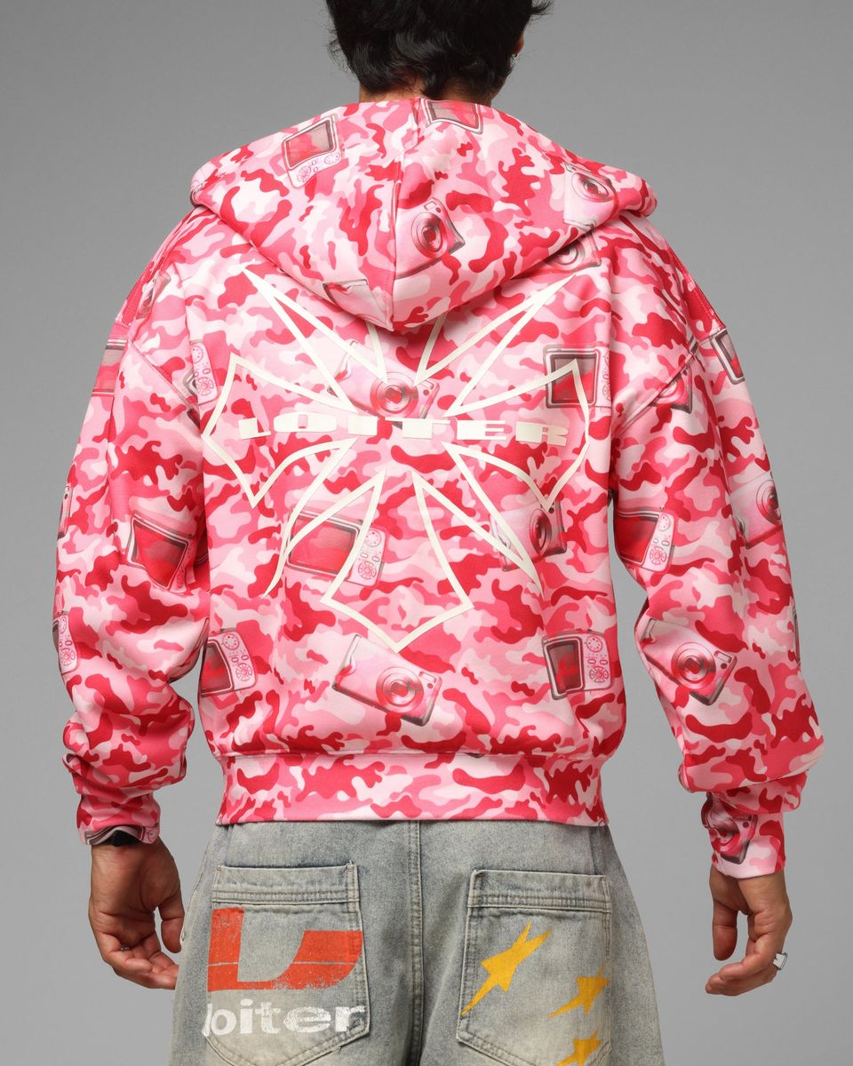 Person wearing a pink and white camouflage jacket on a gray background